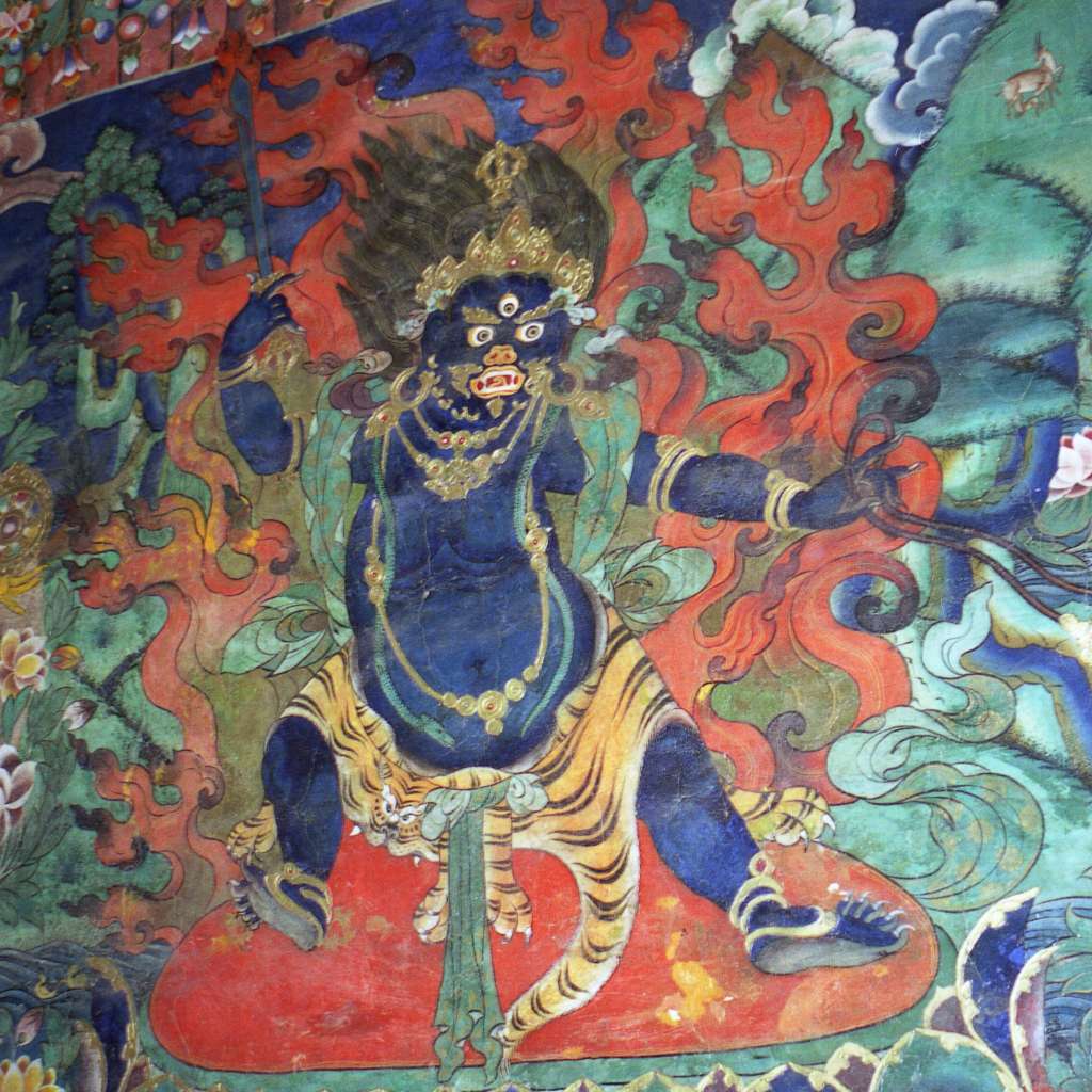 10 Vajrapani Vajrapani (Tib. Chana Dorje) represents power and strength, one of the three main aspects of enlightenment along with compassion (Avalokiteshvara) and wisdom (Manjushri). He is usually royal blue or blue-black and is shown standing on a lotus-sun disc surrounded by wisdom fire. Around his neck, he wears a serpent and below a tiger skin. In his right hand he holds a vajra to cut through the darkness of delusion, and in his left hand a loop for catching demons.
